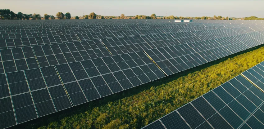 Großflächige Solaranlage auf einem sonnigen Feld, symbolisiert nachhaltige Energiegewinnung und grüne Technologien.