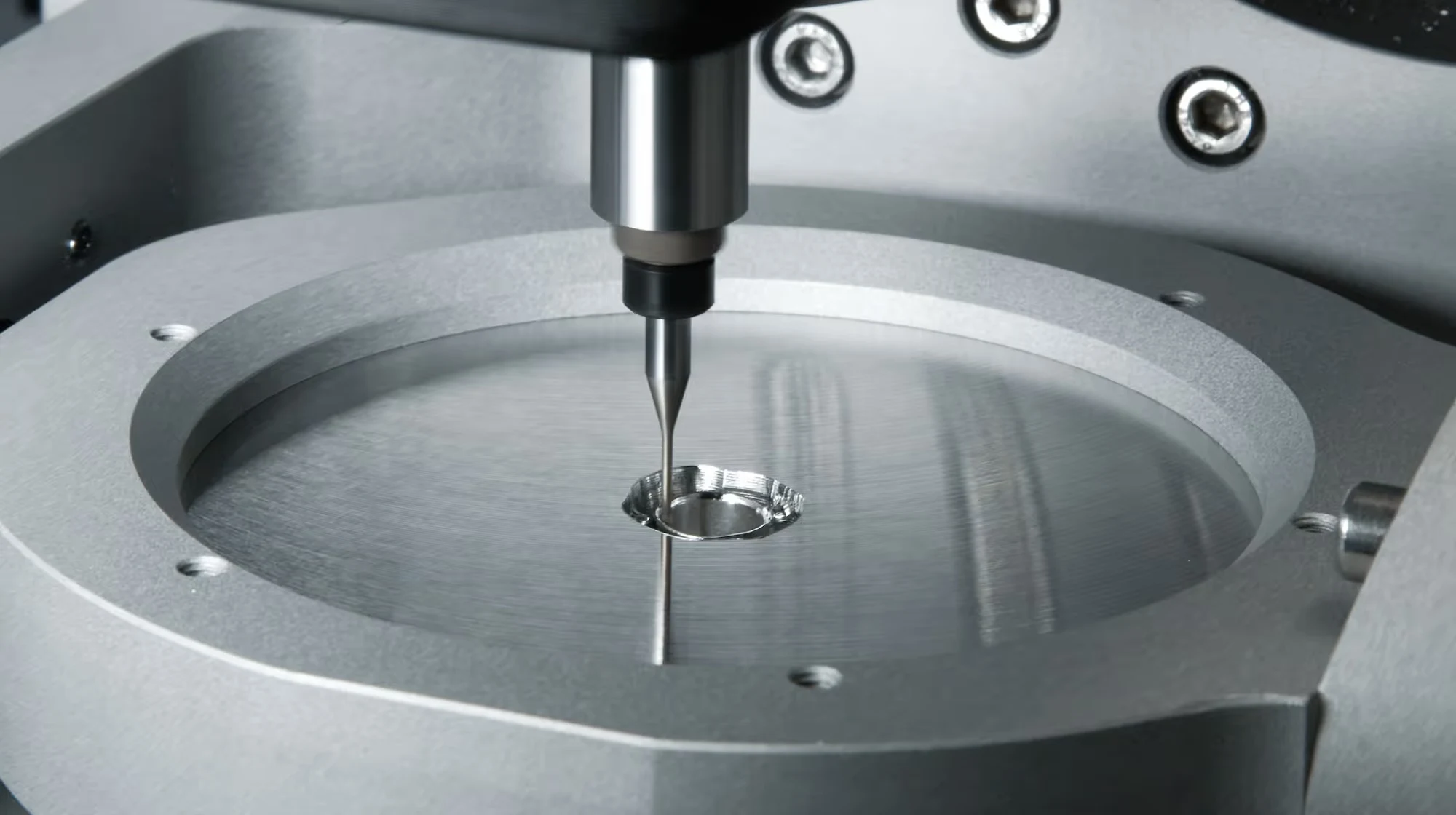 Präzisionsbohrer in Aktion auf einer Metalloberfläche, symbolisiert Hightech-Fertigung und industrielle Präzision.